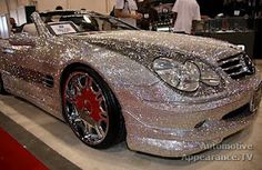 a car covered in shiny silver glitter parked on top of a red carpeted floor