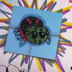 an image of a card with a bug on it's face and some colored pencils in the background