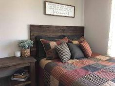 a bedroom with a bed and wooden headboard in the corner next to a window