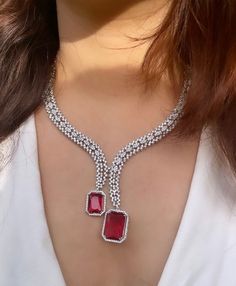 Gorgeous fine quality lab diamonds studded necklace with Ruby red stones in white gold rhodium plating and matching Earrings Item contains: Necklace and earrings  AAA quality cubic zirconia used. Highest quality and craftsmanship Necklace length- 18 inches( adjustable length) Necklace weight-35 gms Earrings length-2 inches  Each earring weighs-7 gms  Closure-Pushback In case of any queries, please feel free to reach out to us. Happy shopping! White Gold Diamond Necklace With Jewels, Diamond White Necklace With Jewels, Diamond Jewel Necklaces For Anniversary, Diamond Jeweled Necklaces For Anniversary, Diamond Jeweled Necklace For Anniversary, Dazzling Cubic Zirconia Bridal Necklace With Prong Setting, Diamond Necklaces With Jewels For Anniversary, Dazzling Ruby Necklace For Gift, White Gold Ruby Necklace With Diamond Cut