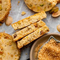 some food is on a table and next to it are two muffins, one with pistachio sprinkles