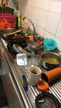 many pots and pans are sitting on the kitchen counter top with utensils