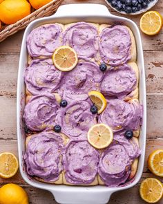 a pan filled with blueberry lemon rolls on top of a table next to oranges