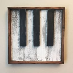 an old piano made out of wood and black keys is mounted on the white wall