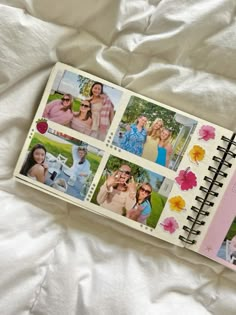 an open photo book with pictures of people on it sitting on a white bed sheet