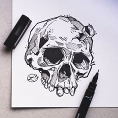 a black and white drawing of a skull on top of a piece of paper next to a marker