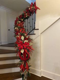 a staircase decorated for christmas with poinsettis and greenery