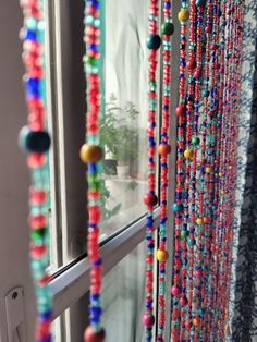 colorful beads hanging from the side of a window