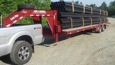 a flatbed truck carrying large pipes in the back