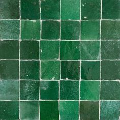 a green tile wall with small squares on it