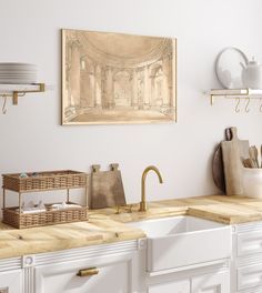 a kitchen with white cabinets and wooden counter tops, an art piece on the wall