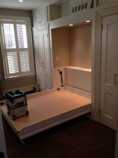 an empty bed room with white walls and wooden floors