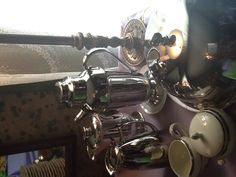 a table topped with lots of silver cups and saucers next to each other on top of a purple table cloth