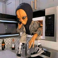 an alien is standing on top of a stove in the kitchen with his head sticking out