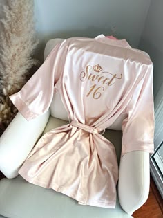 "Get ready for your Mis Quince Años celebration in style with our Quinceañera Satin Robes!  Crafted from soft and silky high-quality satin, these robes are designed to make you feel like a princess on your special day. With different options for text color and designs on the back side, you can customize your robe to match your unique style and personality. Not only are these robes perfect for getting ready, but they're also ideal for Instagram and Pinterest photos. Order yours Mis Quince robe to Quince Pajamas, Champagne Quince Robe, Sweet 16 Rose Gold Dress, Pink Quince Robe, Mis Quince Robe, Pink And Champagne Quinceanera, Quinceañera Robes, Quince Gift Ideas, Birthday Dresses Pink