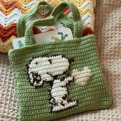 a crocheted bag with a dog on it and a card in the pocket