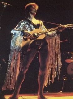 a man with an electric guitar on stage