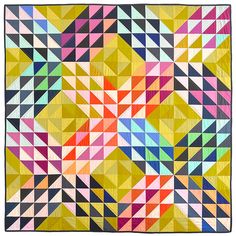 a colorful quilt with many different colored squares on the front and back, as well as an abstract design