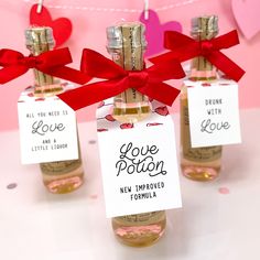 three small bottles filled with love notes and red bows