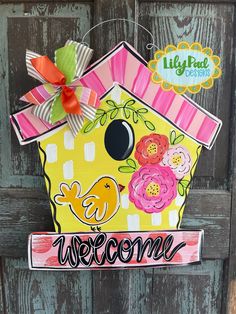 a birdhouse door hanger that says welcome