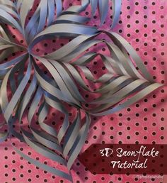 a paper snowflake is sitting on top of a polka dot tablecloth with silver foil