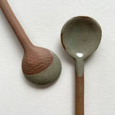 two wooden spoons with different colors and designs on them, one is brown and the other is green