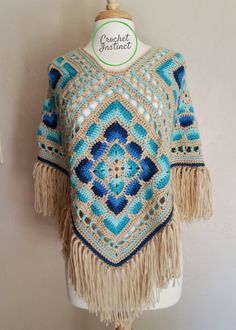 a blue and white sweater with tassels on top of a mannequin