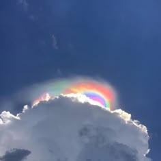 a rainbow appears in the sky above a cloud