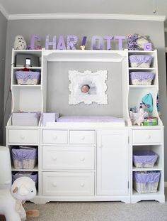 a baby's room is decorated in lavender and white with lots of storage space