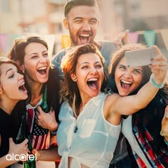 a group of friends taking a selfie with their cell phone at an outdoor event