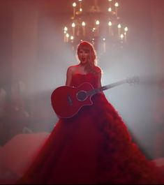 a woman in a red dress holding a guitar