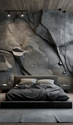 a bedroom with a large bed in front of a rock wall and ceiling lights hanging from the ceiling