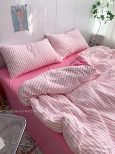 a bed with pink and white striped sheets