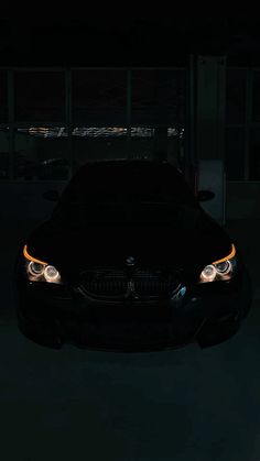 a black car in the dark with its lights on