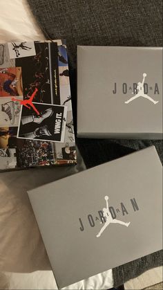 two boxes with jordan stickers on them sitting on a bed next to each other