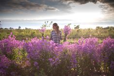 a woman standing in a field of purple flowers