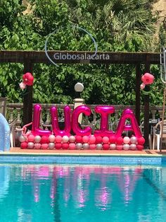 an inflatable sign that says acta next to a swimming pool with flamingos