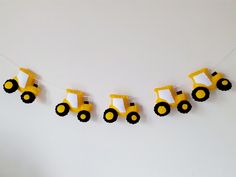 yellow and black construction vehicles are hanging on a string