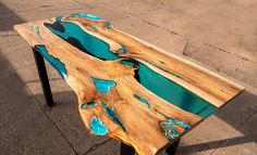 a table made out of wood with blue paint on the top and black metal legs