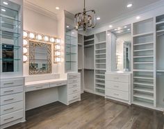 a large walk in closet with lots of drawers and lights on the ceiling, along with a chandelier