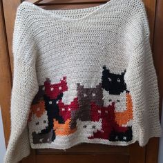 a crocheted sweater with cats and dogs on it