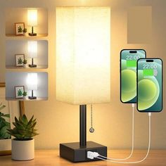 a lamp that is on top of a table next to a cell phone and charger