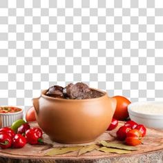 a bowl filled with meat sitting on top of a wooden table next to other food items