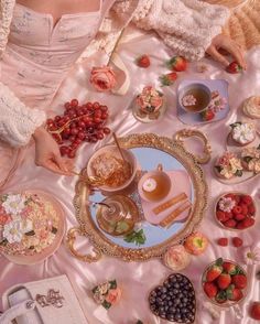 a woman sitting at a table filled with food and desserts next to other dishes