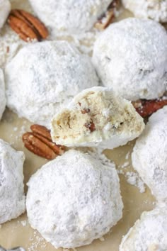 there are some snowball cookies and pecans on the plate with it's bite taken out