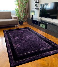 a living room filled with furniture and a flat screen tv on top of a wooden floor