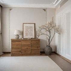 a living room with white walls and wooden furniture