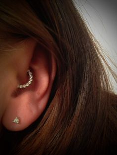 a woman's ear with two small white stones