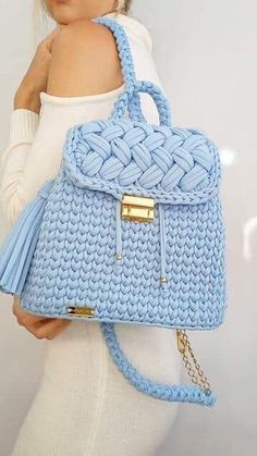 a woman is holding a blue handbag