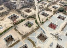 an aerial view of some buildings in the middle of a park with trees and bushes